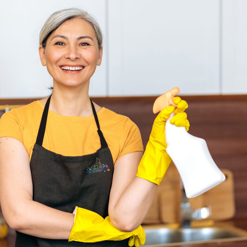 A woman in an apron holding a spray bottle.