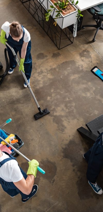 A group of people cleaning the floor with mops and brooms.